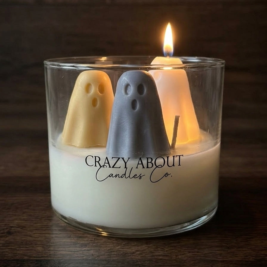 Halloween ghost trio soy candle in clear glass tumbler with lit flames, yellow, gray, and white