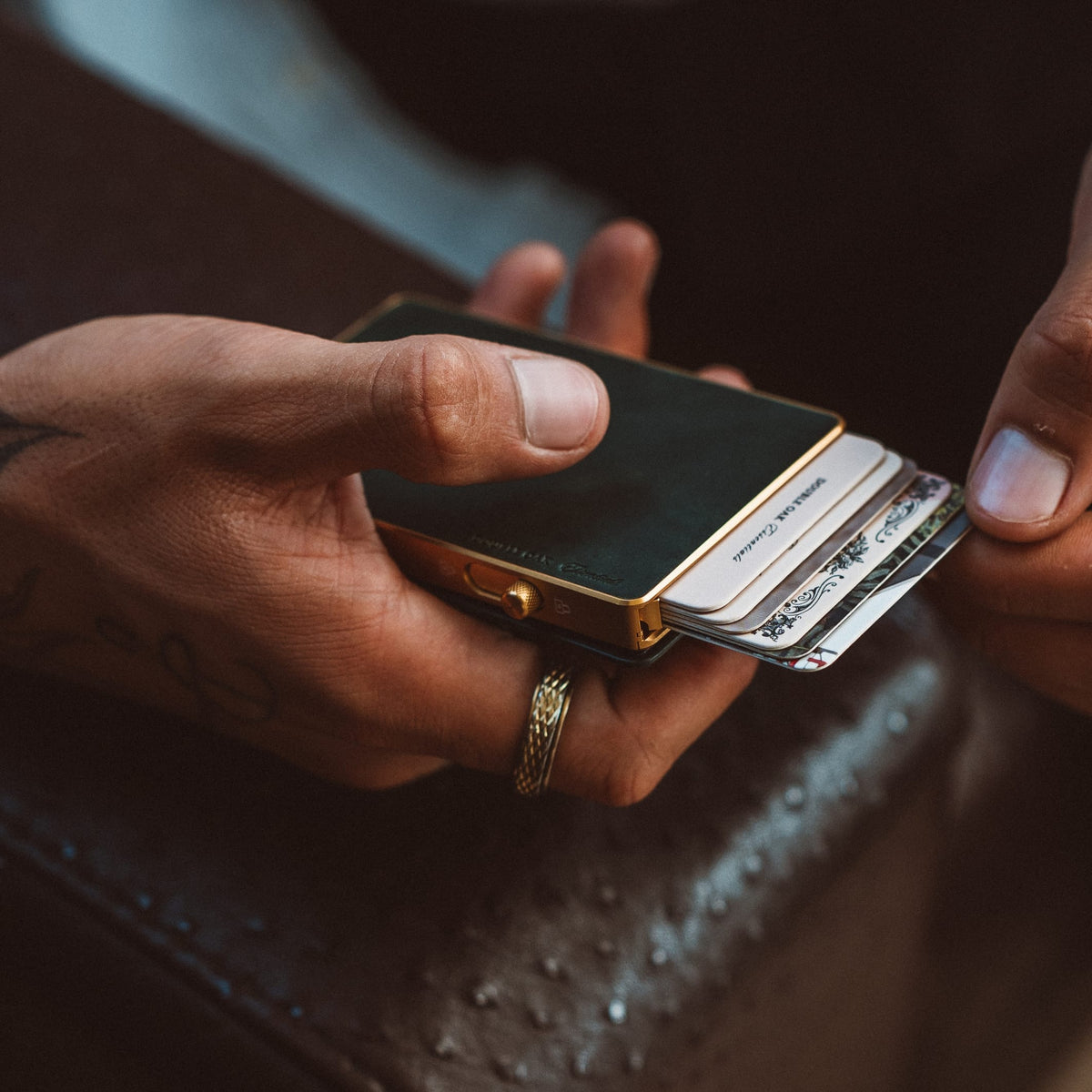 Mod wallet open with card stack and black face, gold-tone clasp visible