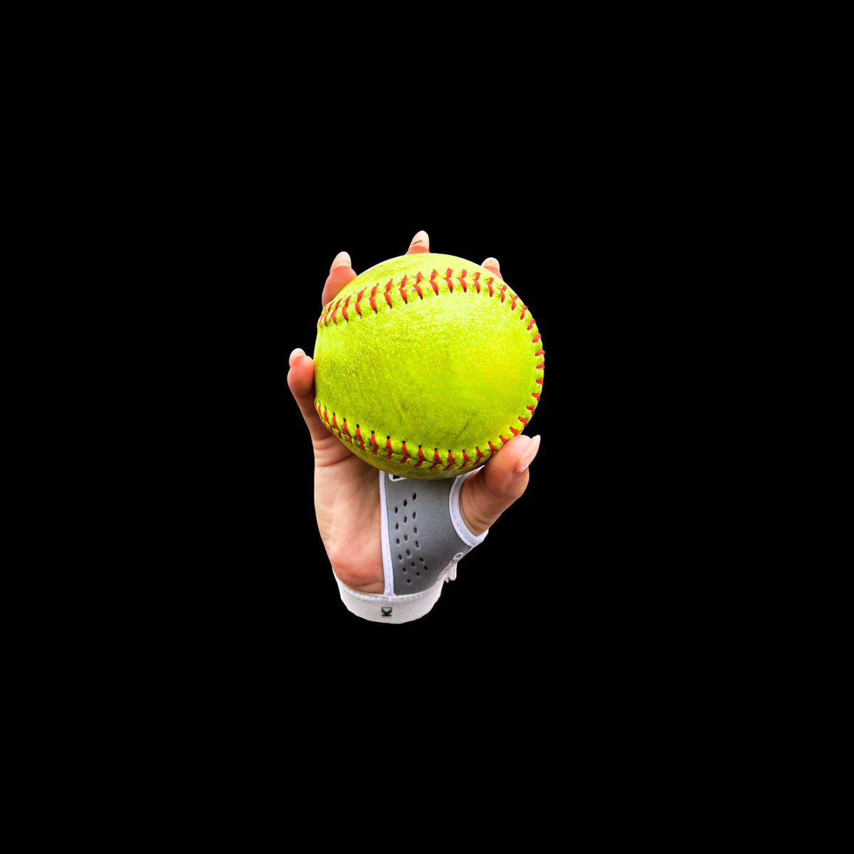 Softball training grip showing neon yellow softball with gray fingerless strap