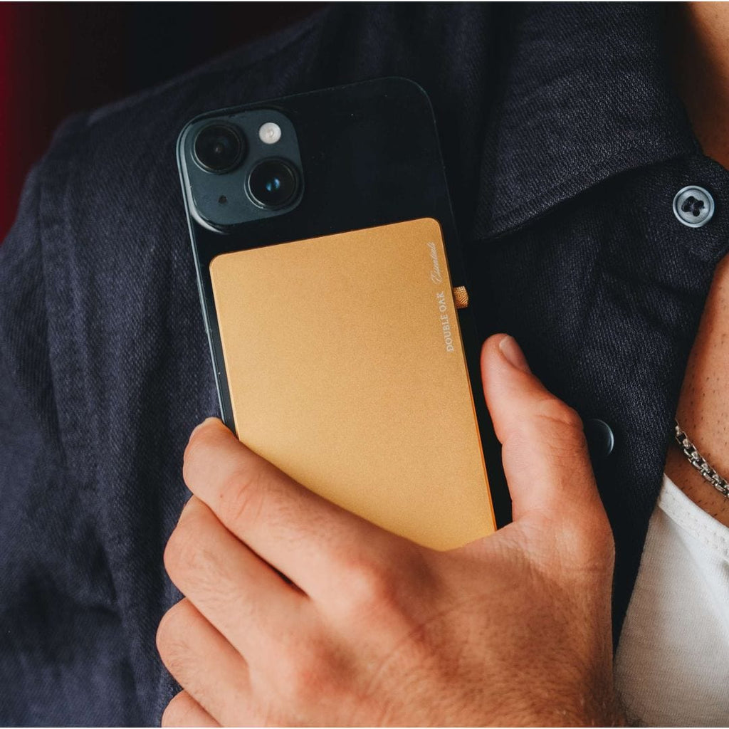 Gold pop-up cardholder held in hand, front panel facing the camera.