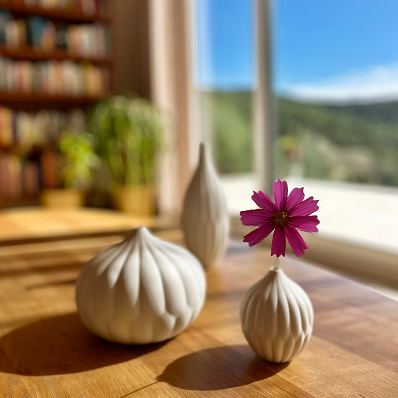 White textured porcelain vases set of 3 with a purple flower and green leaves.