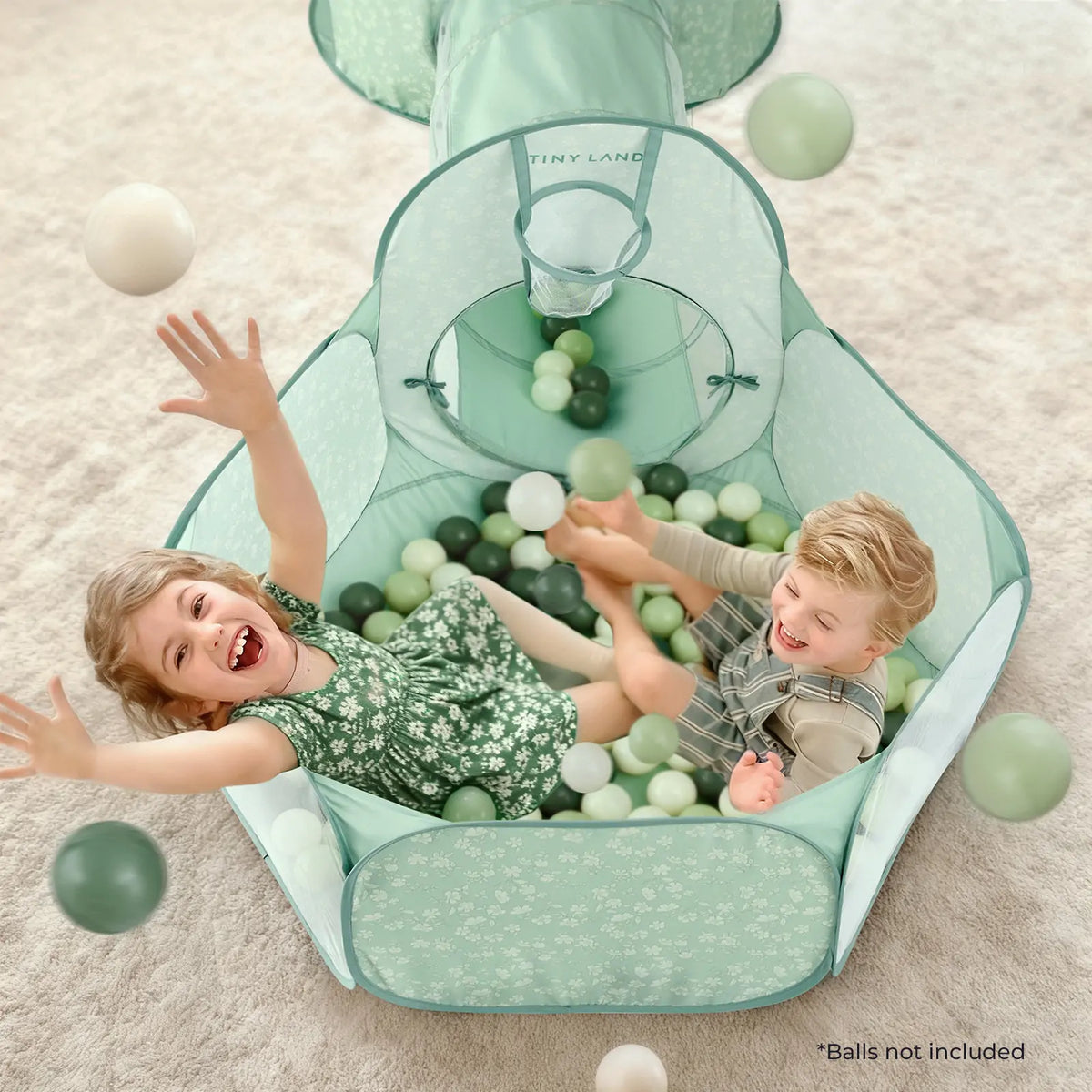 Mint green play tunnel tent with circular front window and padded floor, ball-filled interior
