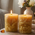 Beeswax candle with embossed floral mother design, lit wick and warm honey color