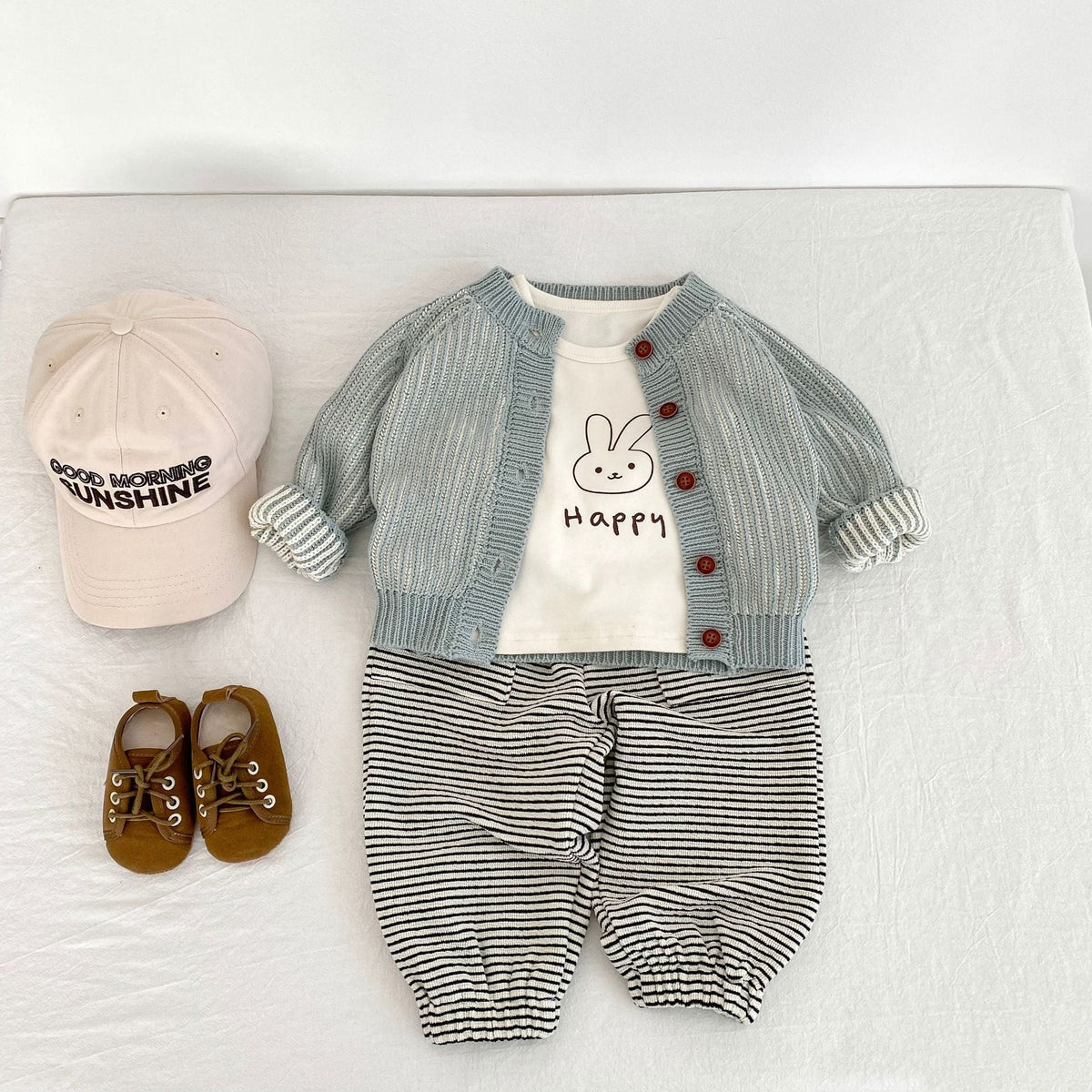 Infant light blue knit coat with red buttons over bunny tee and striped bottoms