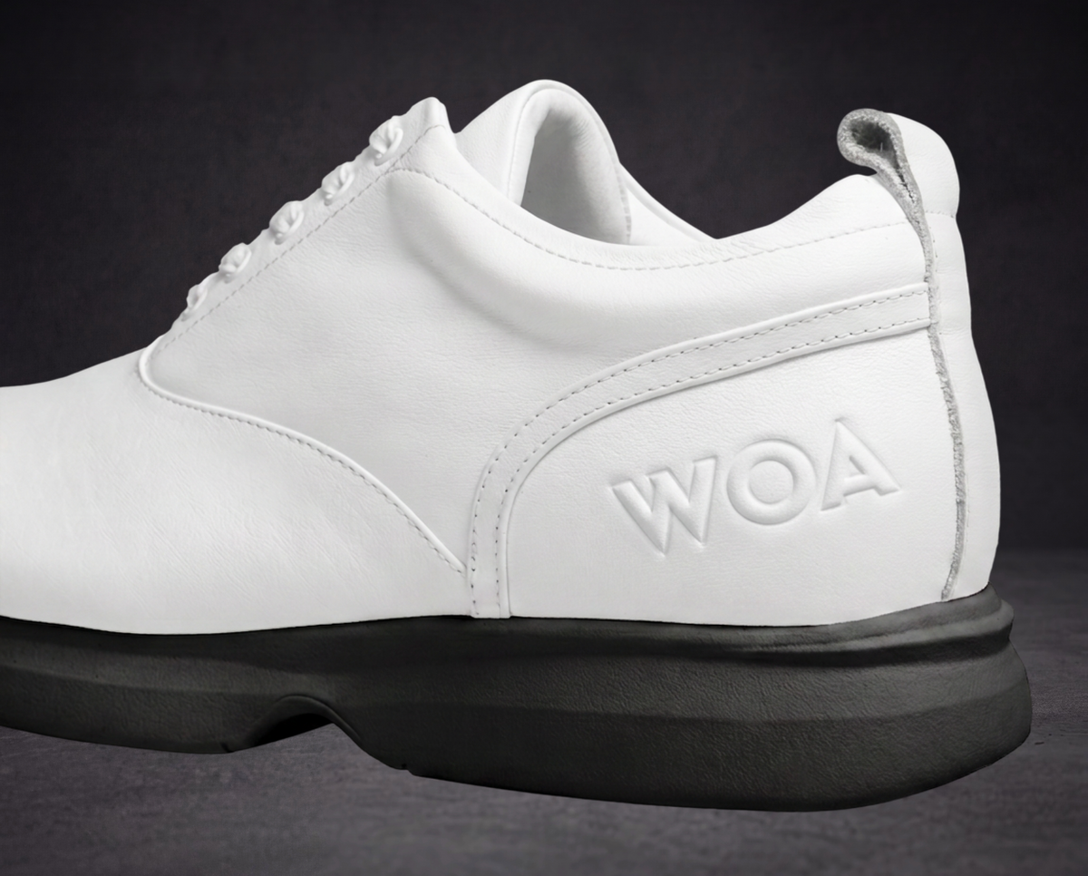 White sneaker side view with WOA logo panel and black platform sole