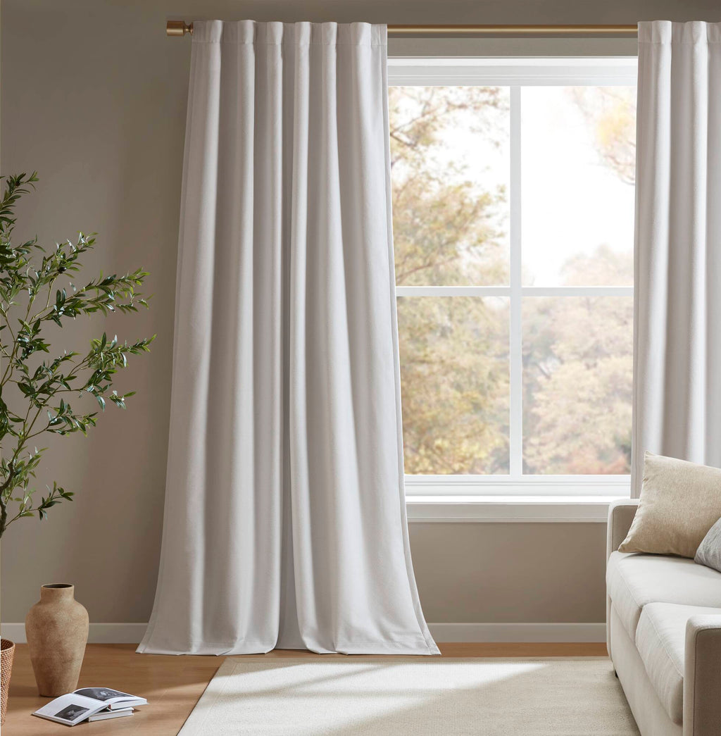 White blackout curtain panels framing a window with long, smooth folds