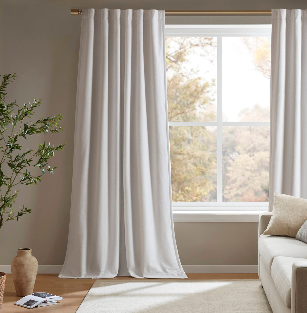 White blackout curtain panels framing a window with long, smooth folds