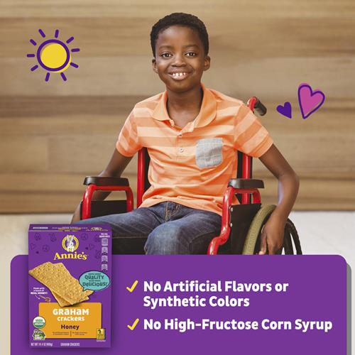 Annie's graham crackers box held by a child, showing no artificial flavors claim.