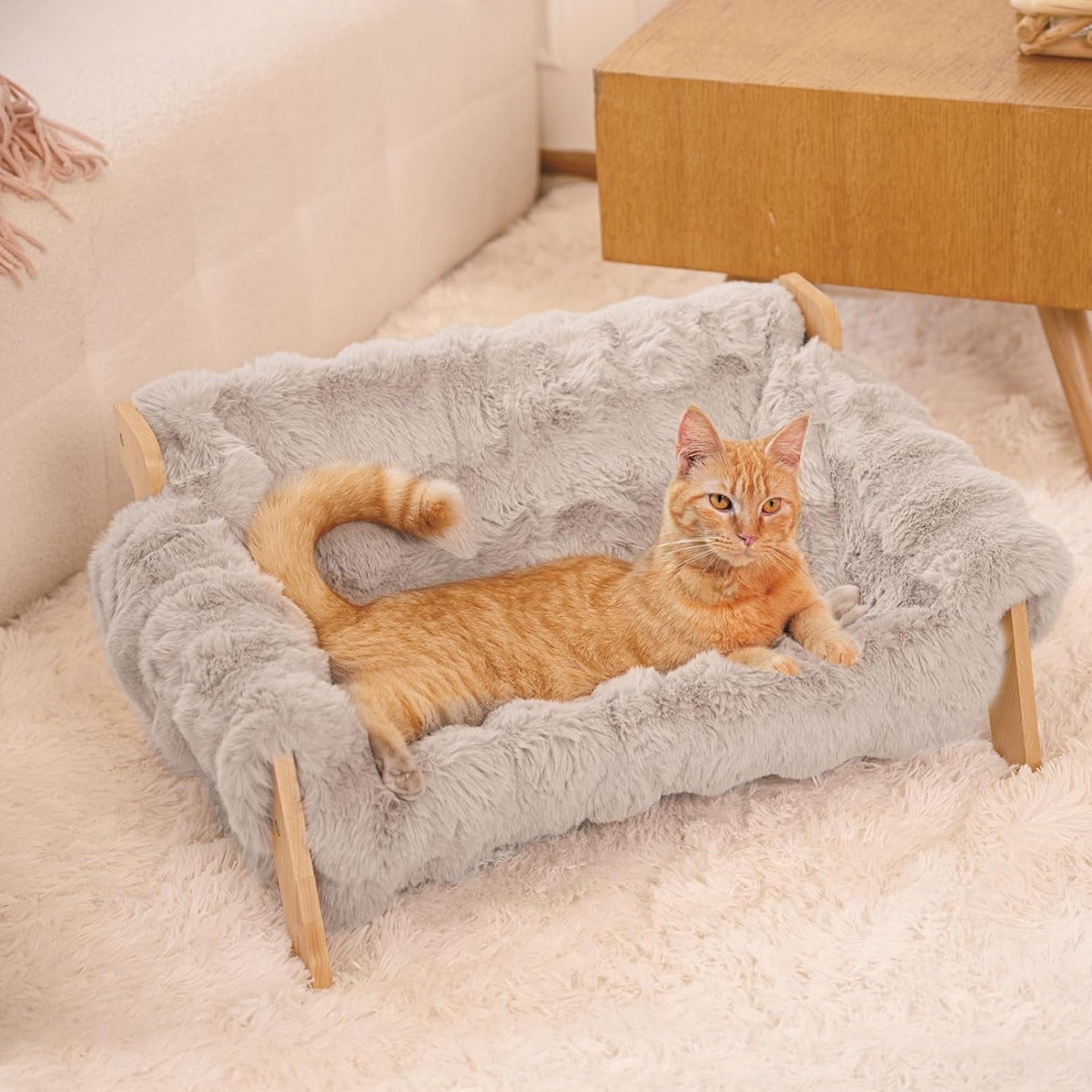 Gray fluffy cat couch bed with a wooden frame and raised cushion sides.
