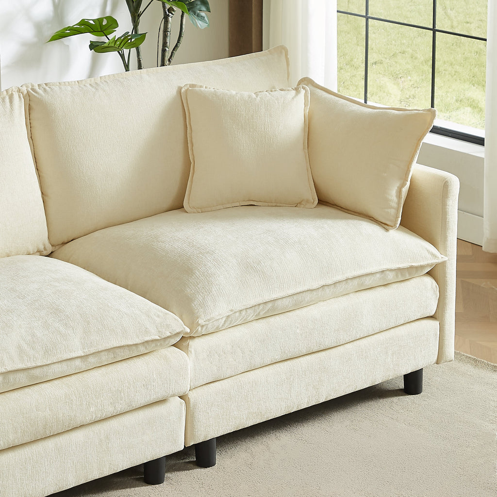 Cream chenille sofa section with ottoman and three accent pillows