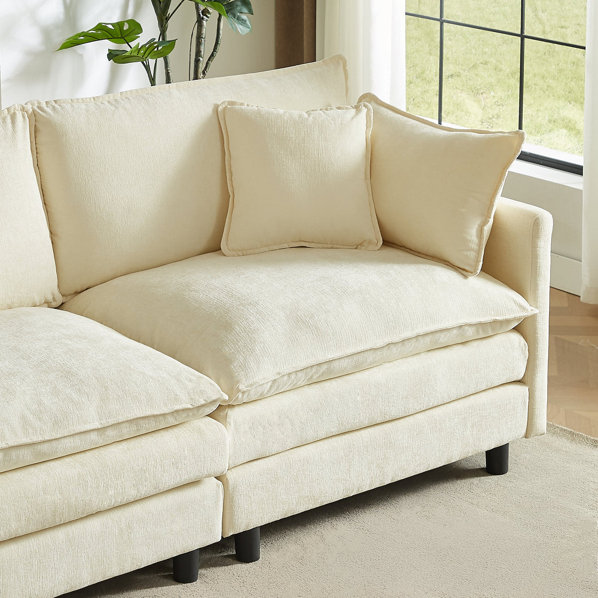 Cream chenille sofa section with ottoman and three accent pillows