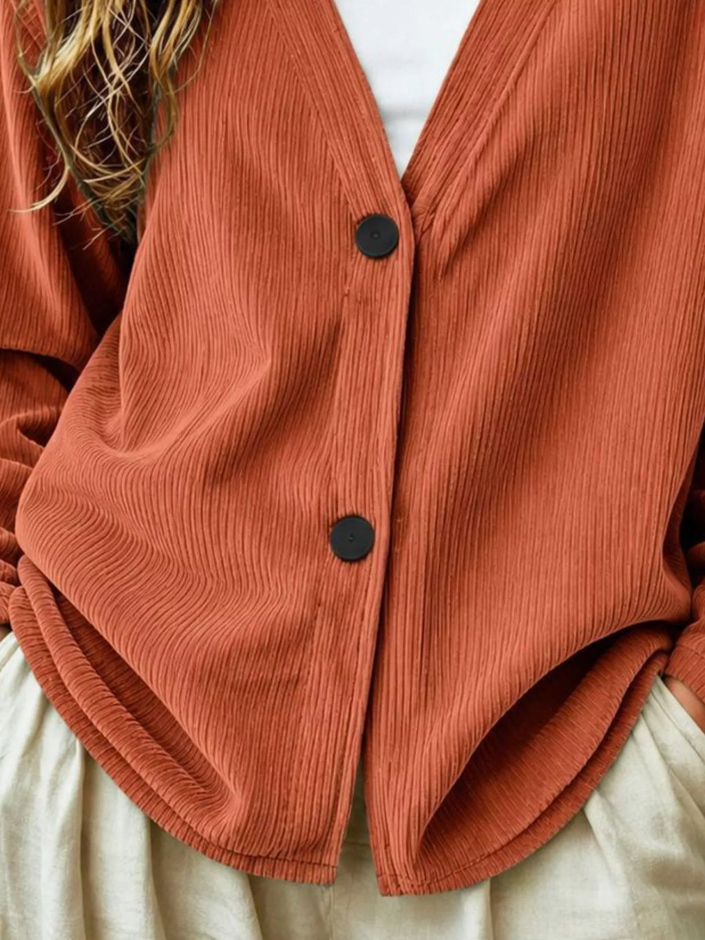 Rust brown corduroy cardigan close-up, V-neck button front with two dark buttons