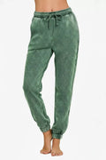 Acid-wash fleece sweatpants in dark green with drawstring and side pockets, elastic cuffs