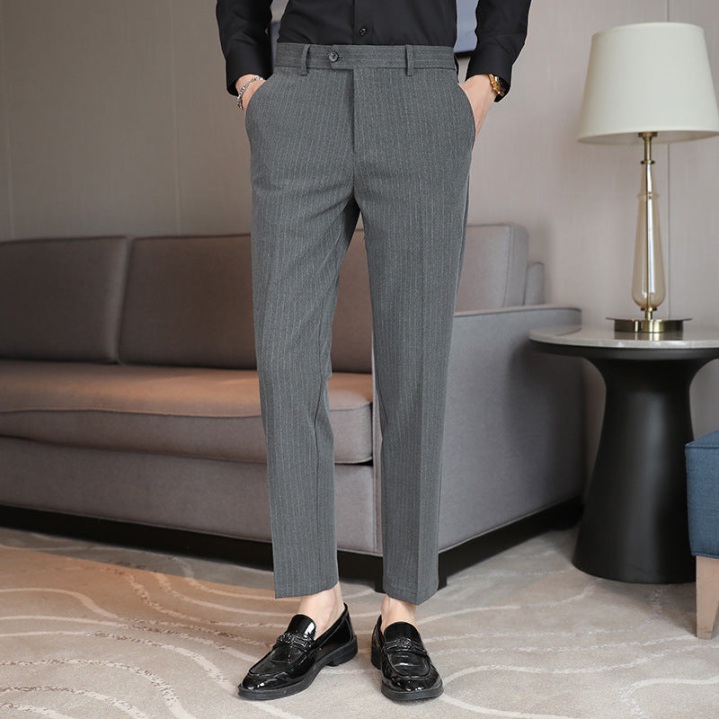 Men's slim-fit gray trousers with belt loops, button closure, and tapered legs