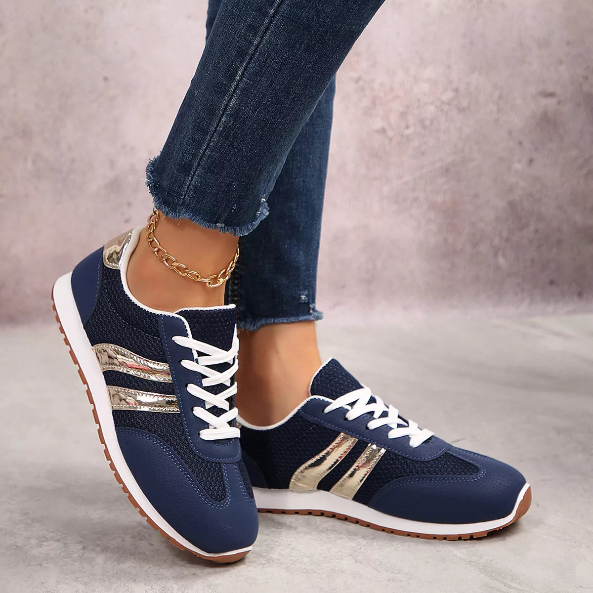 Blue lace-up round toe sneakers with gold striped accents and white lace-up closure