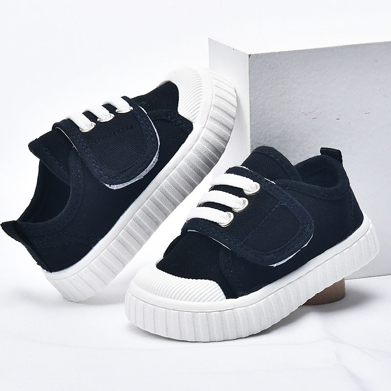 Black baby first-walker sneakers with white lace eyelets and chunky white sole