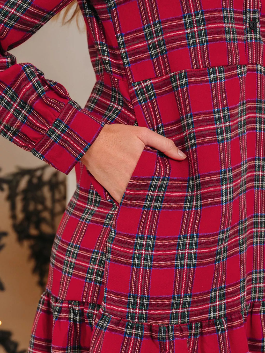Close-up of burgundy plaid mini dress fabric and tiered ruffle hem detail