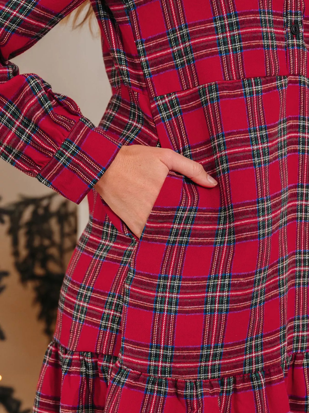 Close-up of burgundy plaid mini dress fabric and tiered ruffle hem detail