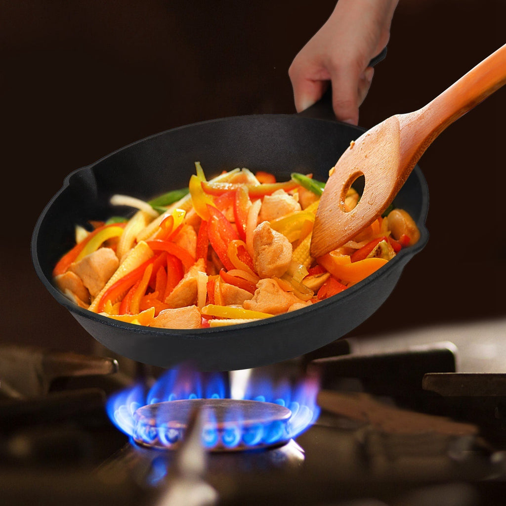 Cast iron skillet with sautéed vegetables on a gas stove