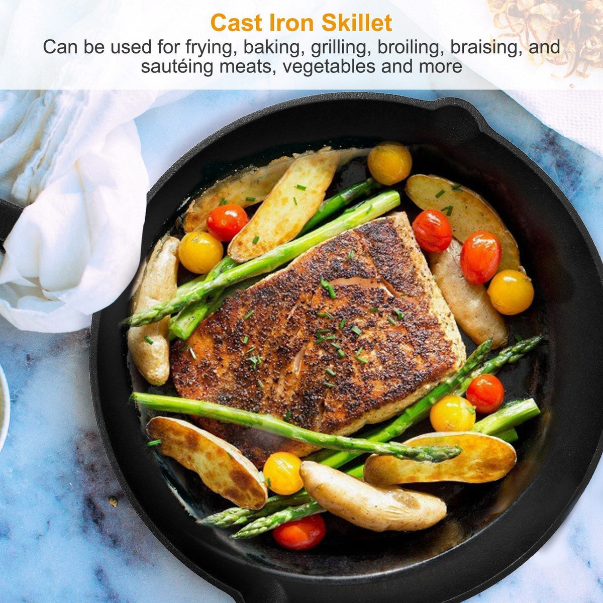 Black cast iron skillet filled with seared meat, asparagus, and tomatoes