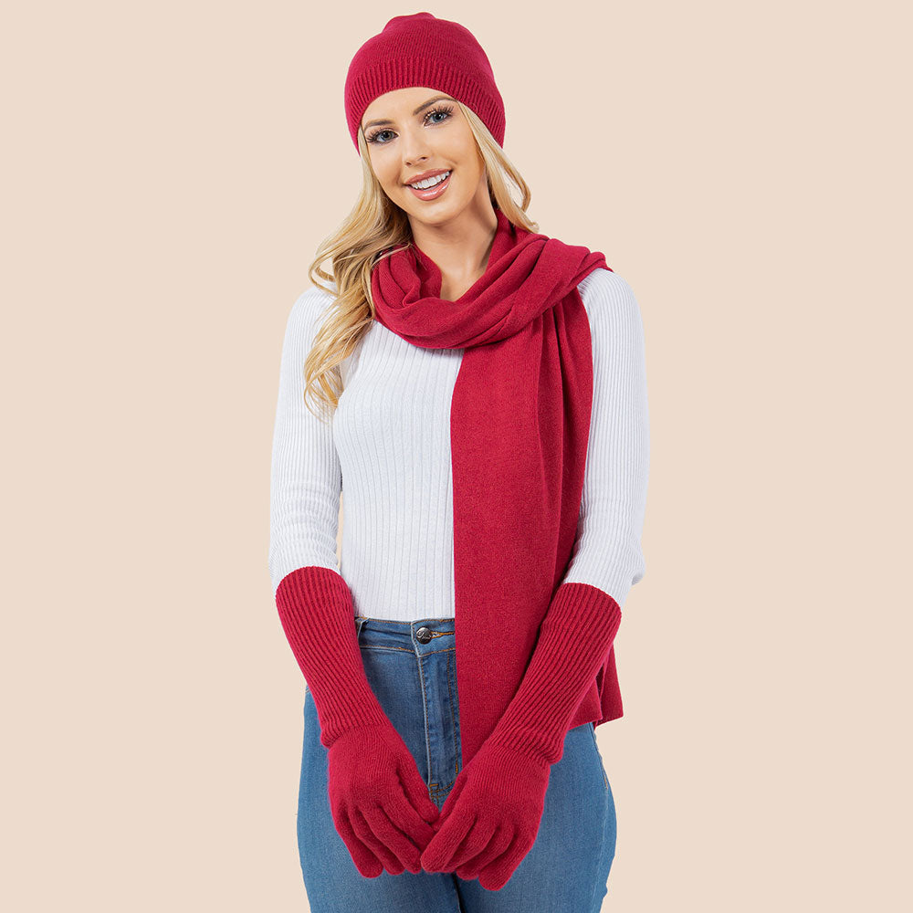 Deep red knit beanie, matching scarf, and gloves set for winter wear