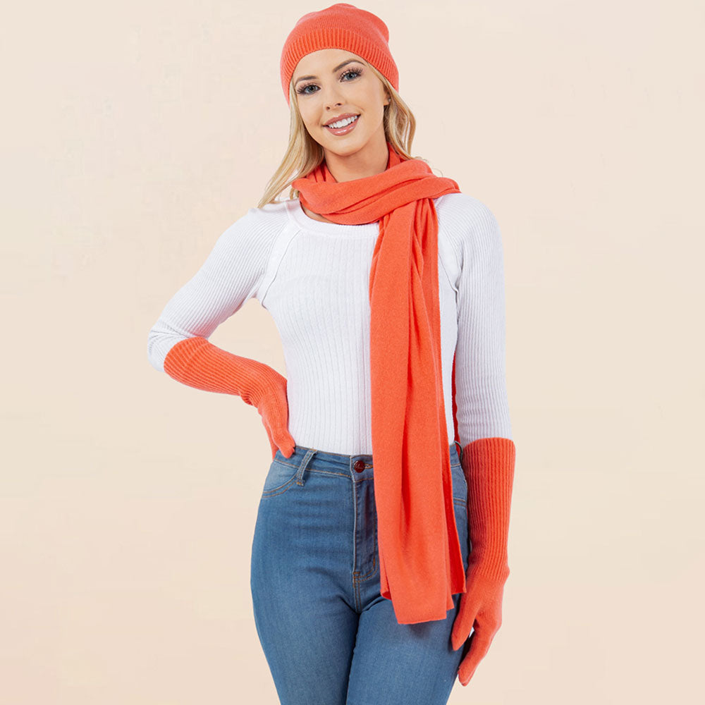 Coral orange knit beanie, matching scarf, and gloves set for winter wear