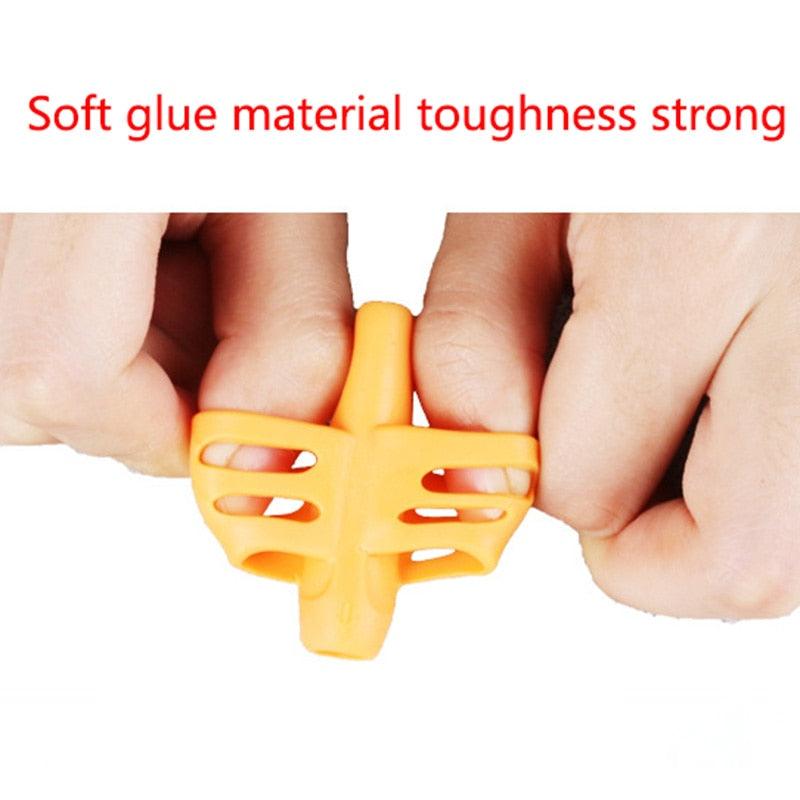 Orange triangular pen grip held between fingers, showing two cutout sections
