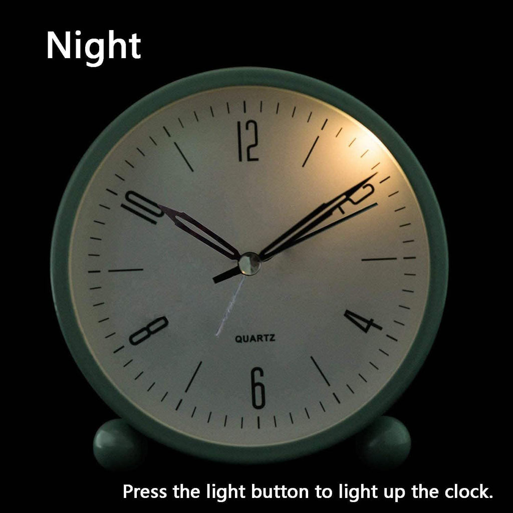 Green analog alarm clock with illuminated dial and black hands in front view