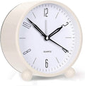 White analog alarm clock with black hands and twin bells on front stand