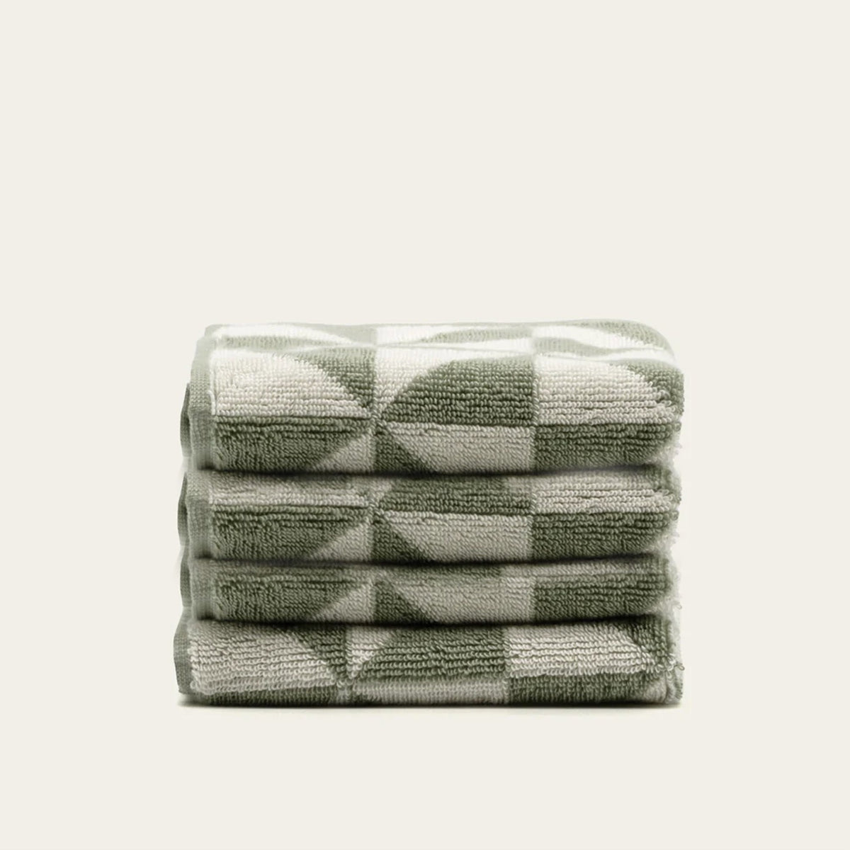 Folded cotton towel stack, sage green and ecru geometric square pattern