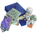 Assorted reusable cloth furoshiki wraps with blue, green, purple patterns and tied bows