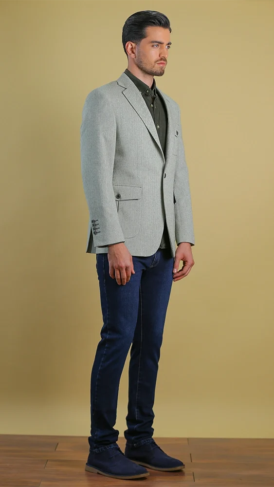 Single-breasted olive-toned blazer with notch lapels and flap pockets, worn with jeans