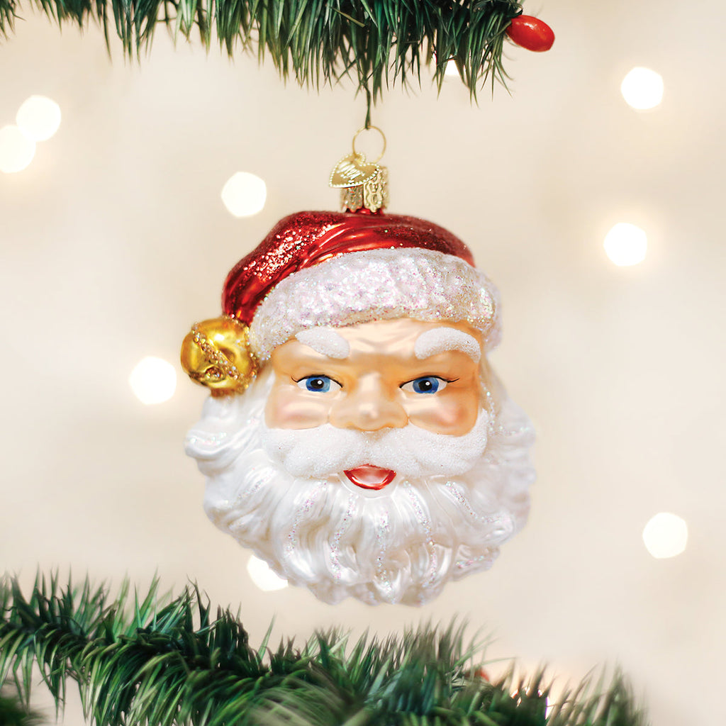Santa face glass ornament with a glittery red hat, gold bell, and white beard