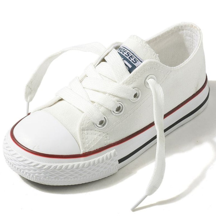 White low-top canvas sneakers with lace-up closure and red/black trim