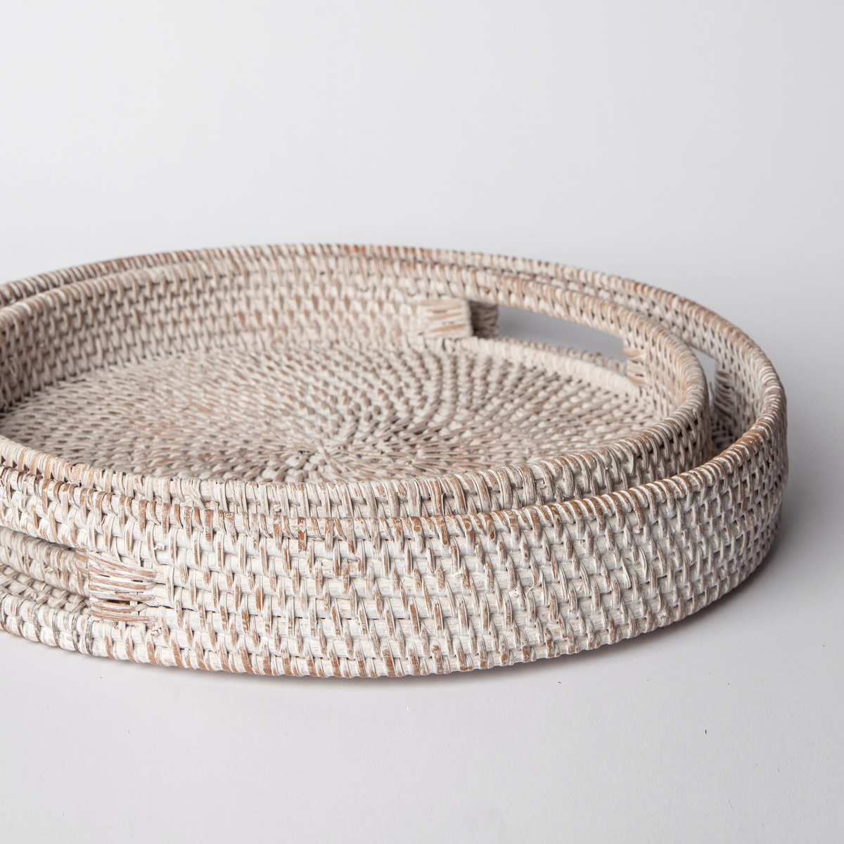 Round woven rattan tray with white finish and open center, side view