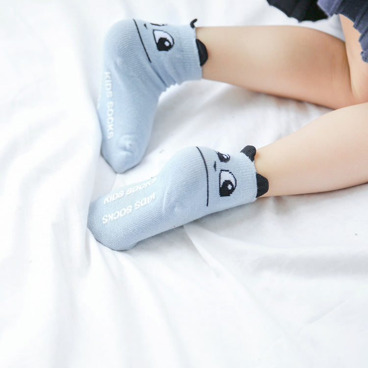 Pair of light blue kids cotton baby socks with cartoon animal and printed text on the side.