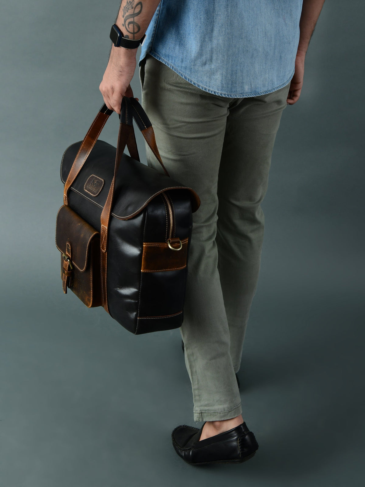 Black and brown leather top-handle briefcase bag with crossbody strap, carried