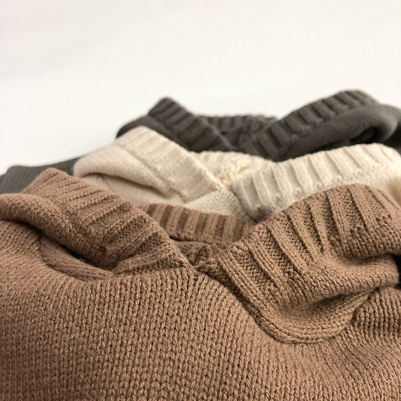 Children's knit hoodie close-up showing hood and ribbed trim in brown, cream, and gray