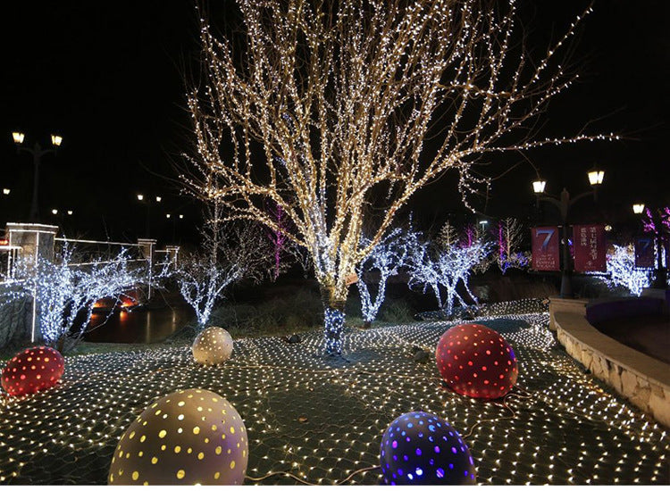White LED fishnet string lights with lit dome decorations and colorful yard ornaments