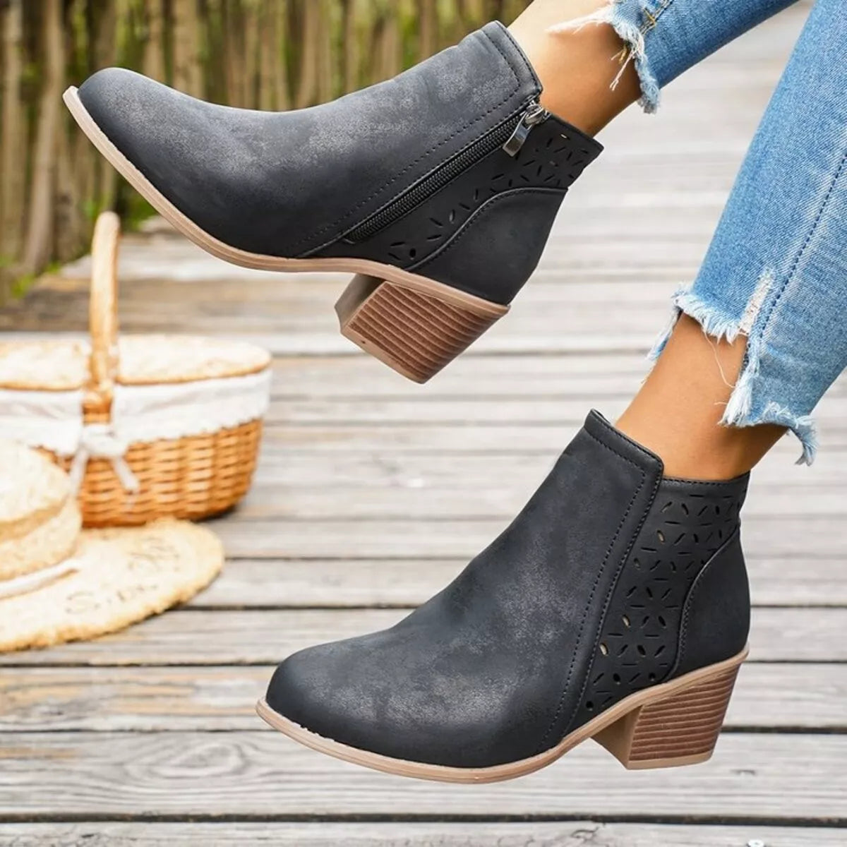 Black ankle boots with side zipper, block heel, and cutout perforation panels
