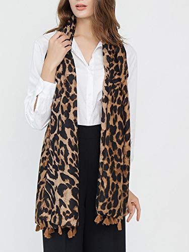 Leopard print tassel scarf wrap worn around the neck over dark pants.