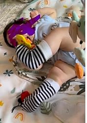 Baby lying down with striped bug rattle socks and colorful insect rattle toys