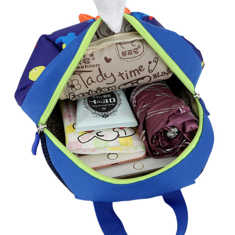 Blue dinosaur print kids backpack open top with neon-green zipper trim and contents inside