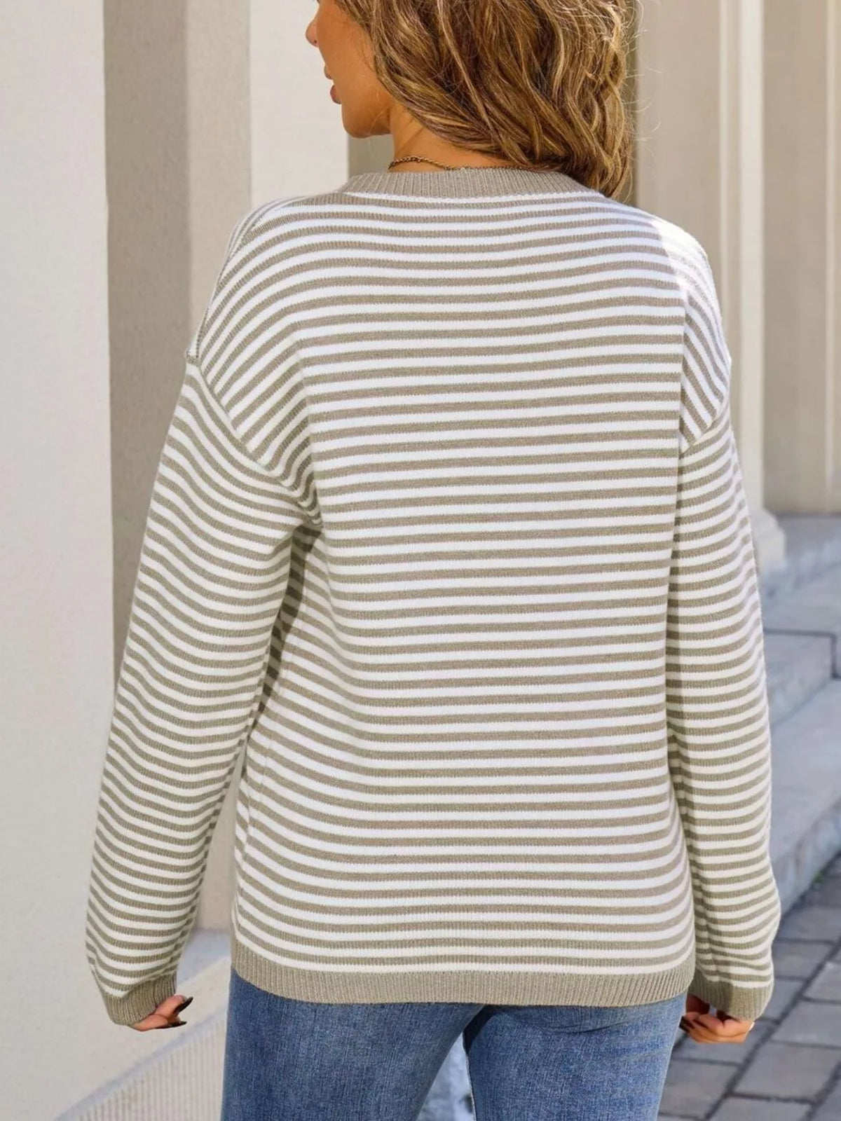Back view of striped round-neck sweater with long sleeves and ribbed cuffs, light tan