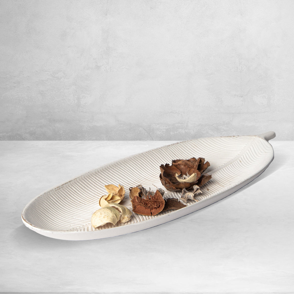 Light white leaf-shaped decorative tray with ribbed lines and dried flower pieces