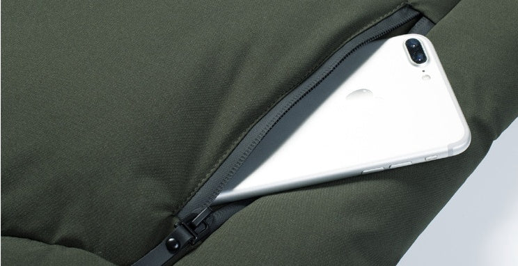 Dark green heated coat sleeve pocket with smartphone partially inserted