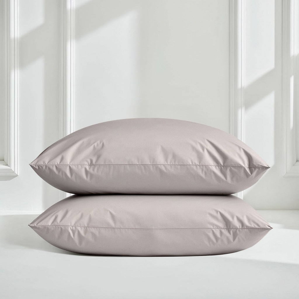 Light gray sateen pillow shams stacked on matching duvet