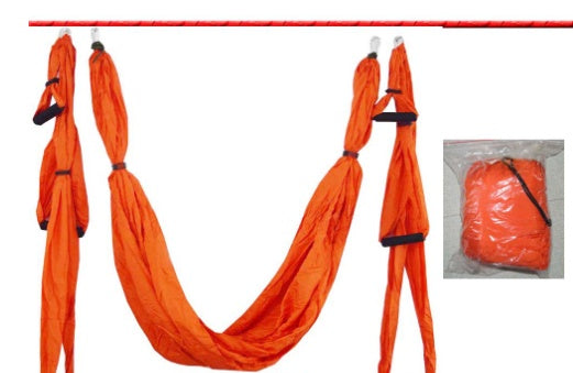 Orange aerial yoga hammock swing with hanging loops, end straps, and storage bag