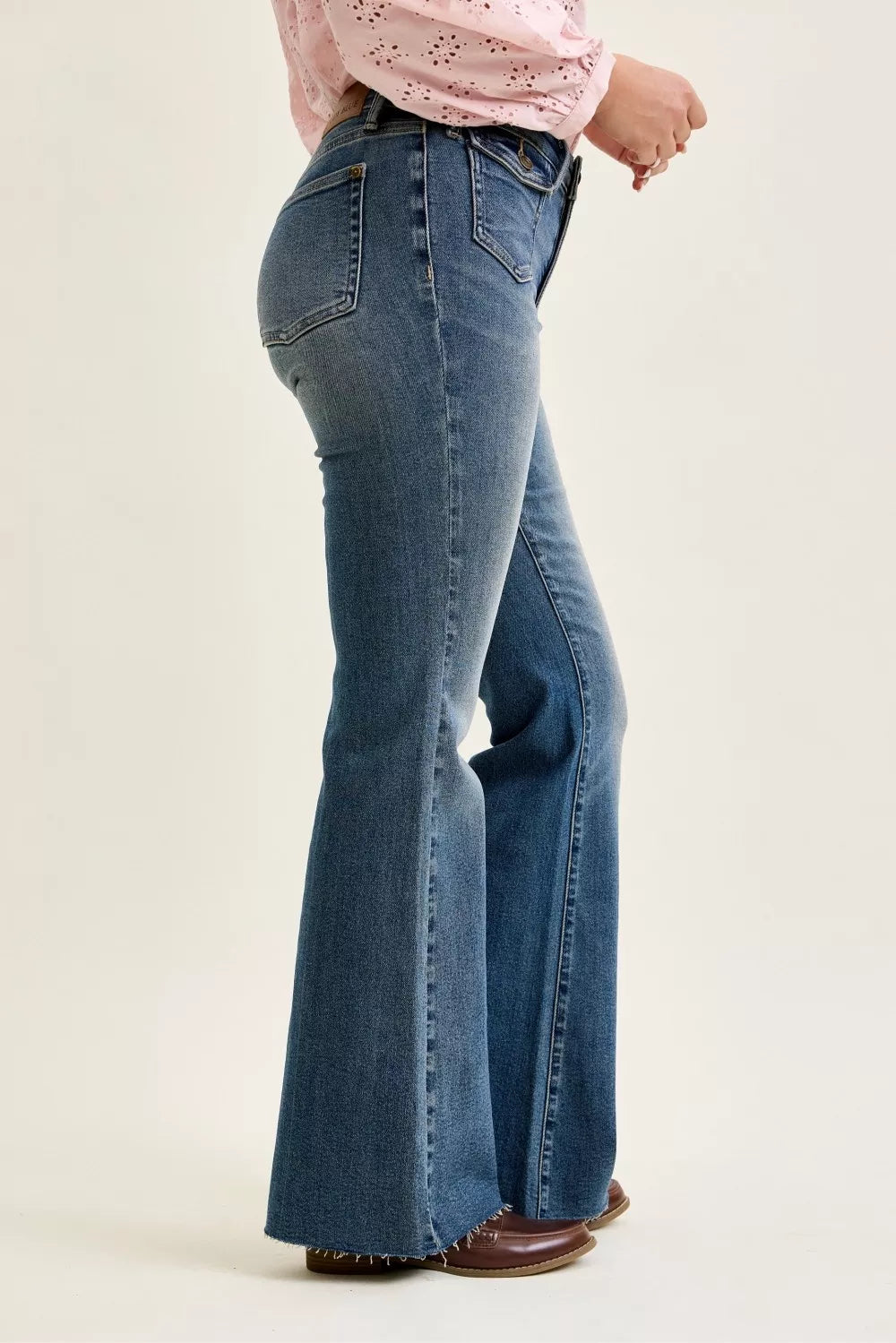 Mid-rise blue flare jeans with front flap pocket detail and stitched seams
