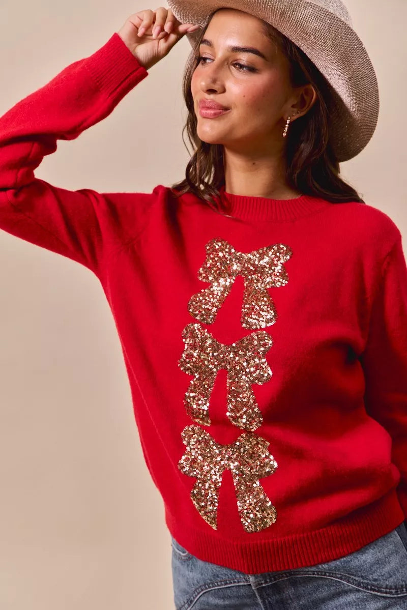 Red sweater with gold sequin bow ribbon centerpiece and textured sparkle detail